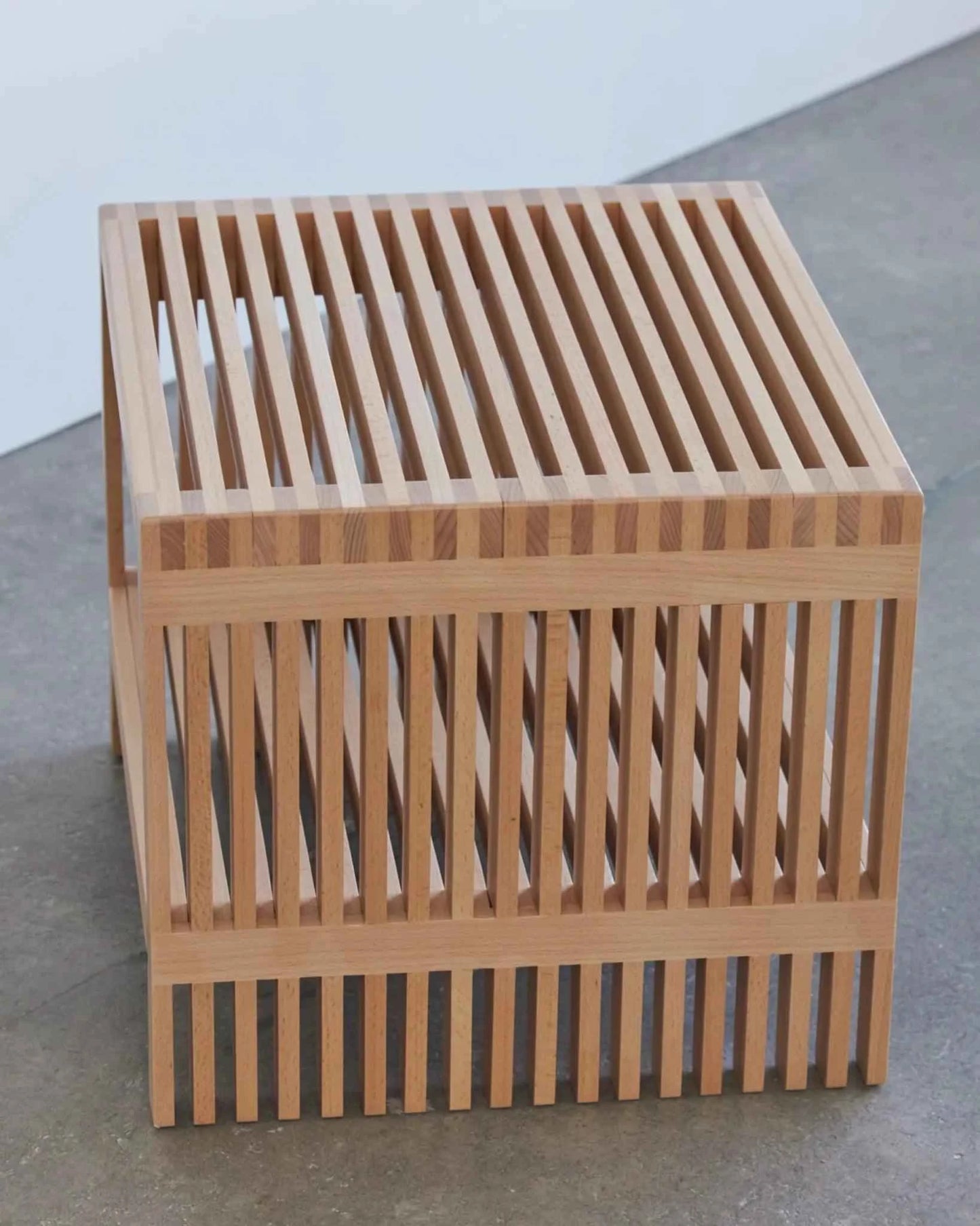 A modern slatted wood side table with a natural finish.