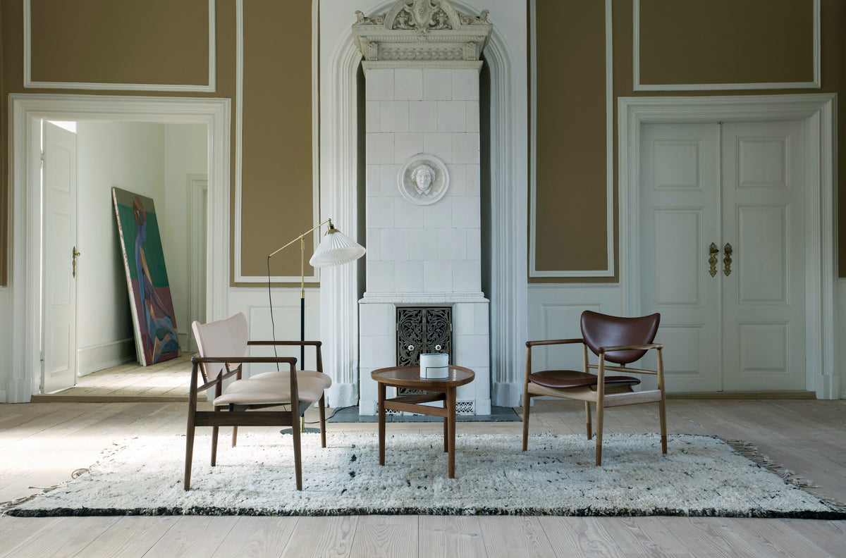 48 Lounge Chair brown leather chair on right in a furnished room; original oak and walnut design reference