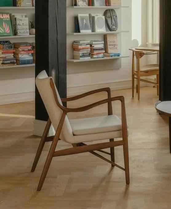 A Finn Juhl 45 Chair with a teak wood frame and light-colored upholstered seat and backrest.