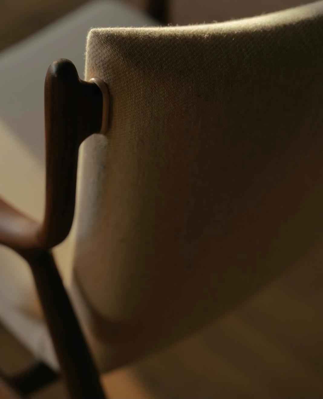 A close-up view of the teak wood frame and upholstered backrest of the Finn Juhl 45 Chair.