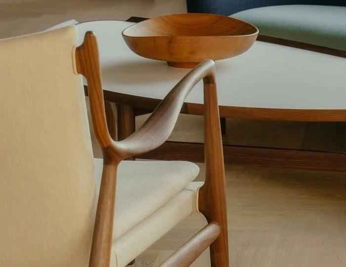 A Finn Juhl 45 Chair with a teak wood frame and light-colored upholstered seat and backrest.