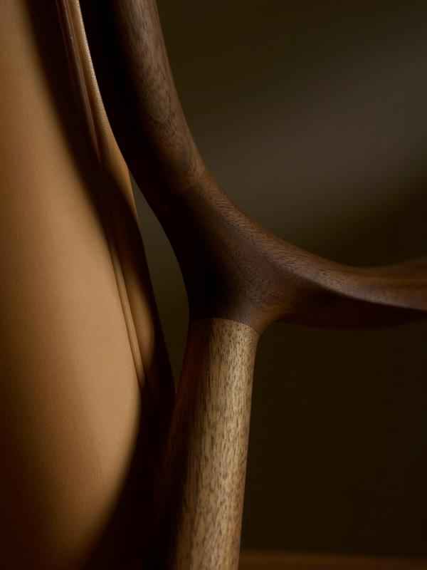 A close-up view of the organic wooden frame and leather upholstery of the Finn Juhl 45 Chair.