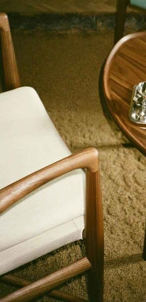 A Finn Juhl 45 Chair with a light-colored upholstered seat and a curved wooden frame.