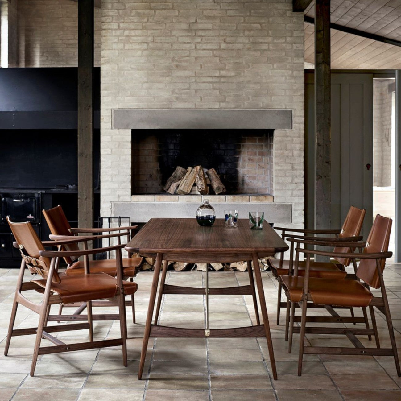 The BM1160 Hunting Table in solid wood with metal brace bars, surrounded by leather dining chairs.