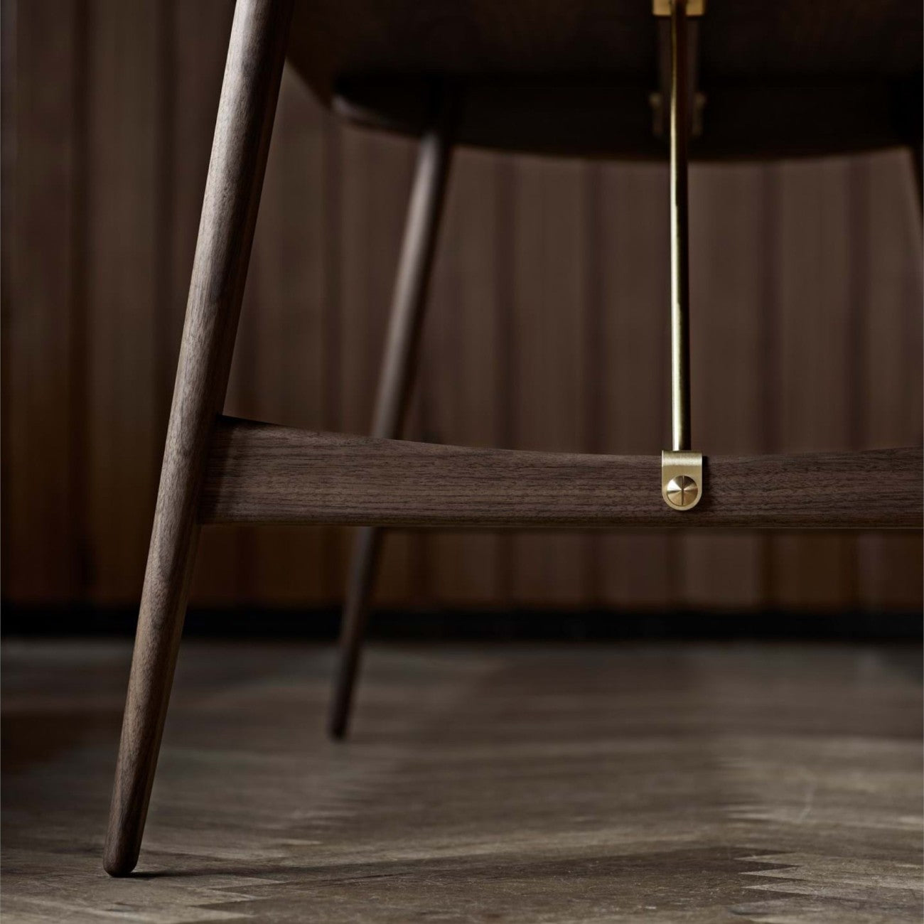Close-up of the BM1160 Hunting Table showing solid wood legs and a brass metal brace bar.