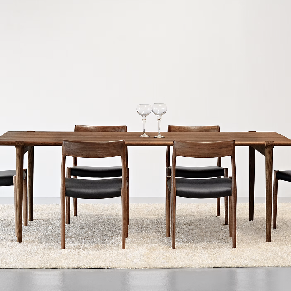 Original J.L. Møller Model 14 design reference — front view in a dining setting. Source: BLU KAT. Custom Gulmohar teak version may differ.