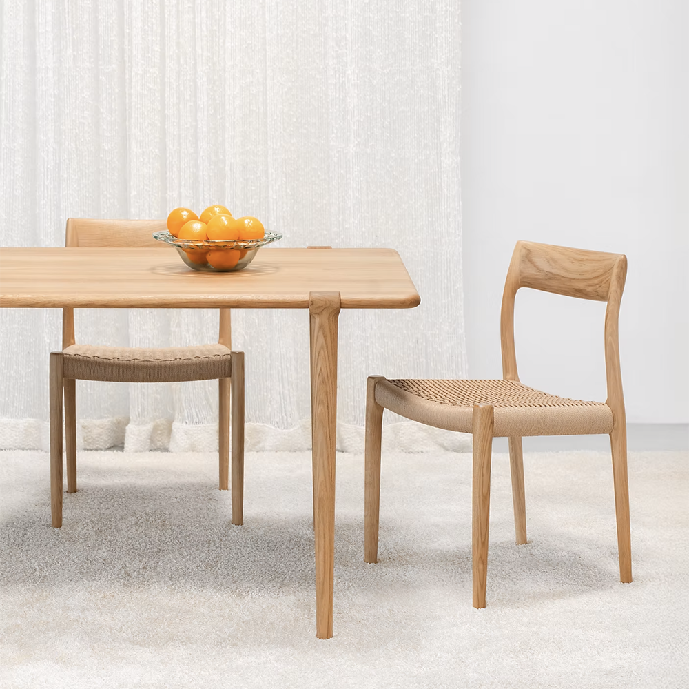 Original J.L. Møller Model 14 design reference — end view in a dining setting. Source: BLU KAT. Custom Gulmohar teak version may differ.