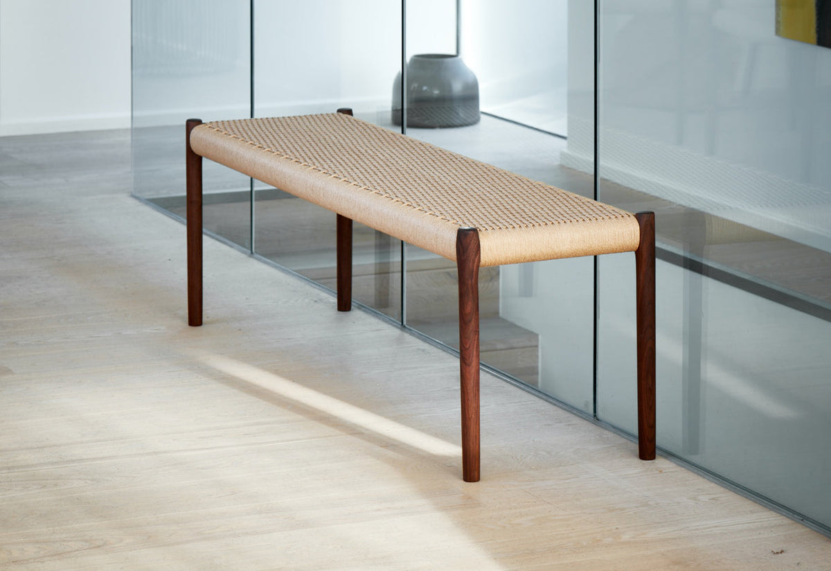 Original J.L. Møller Model 63 design reference — three-quarter view in an interior setting. Source: twentytwentyone. Custom Gulmohar teak version may differ.