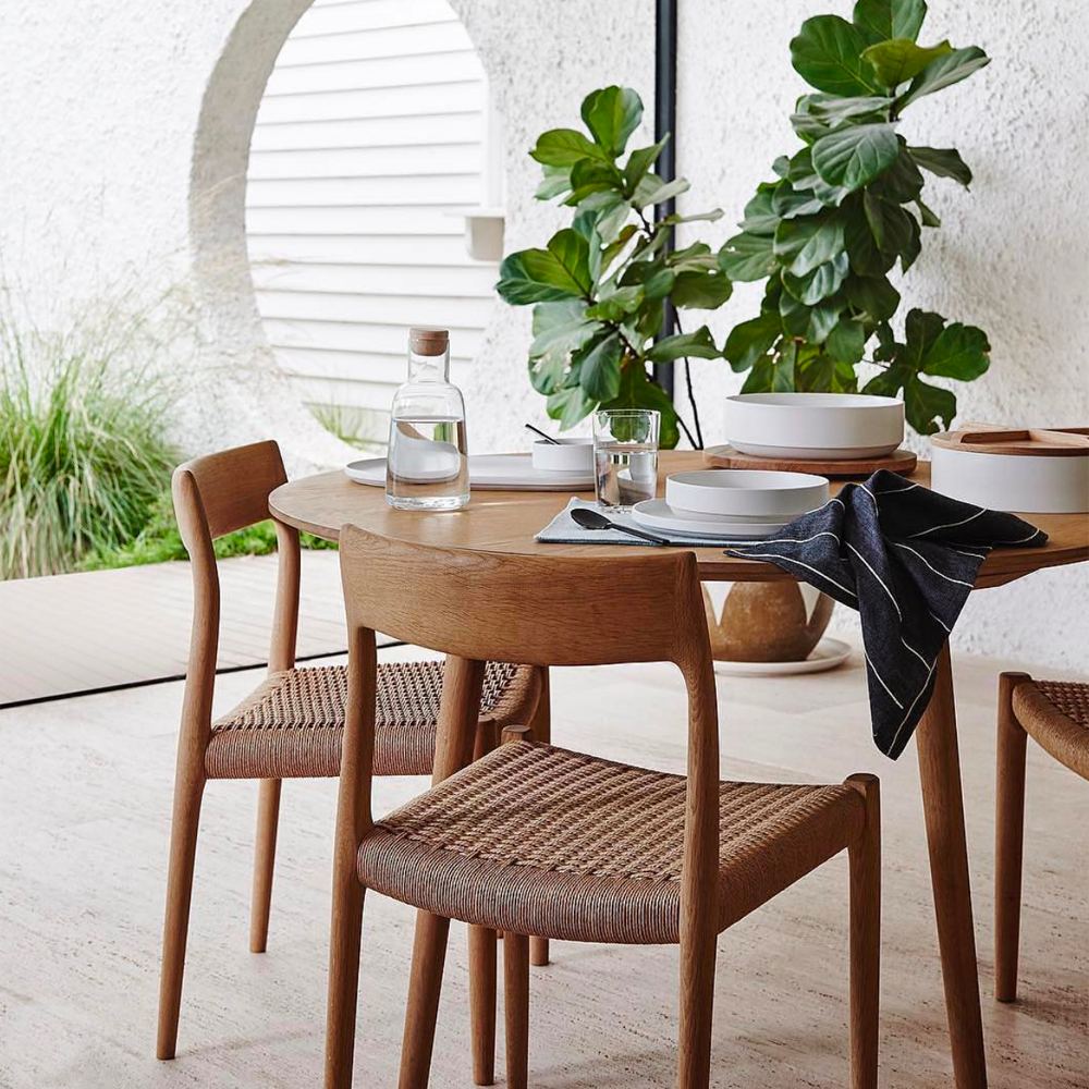 Original J.L. Møller Model 77 design reference — three-quarter view in a dining setting. Source: BLU KAT. Custom Gulmohar teak version may differ.