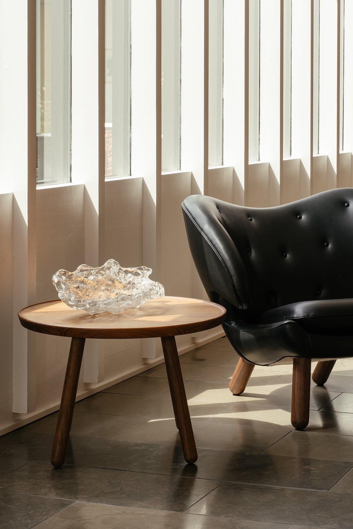 Pelican Coffee Table lifestyle view beside lounge seating; original walnut design reference
